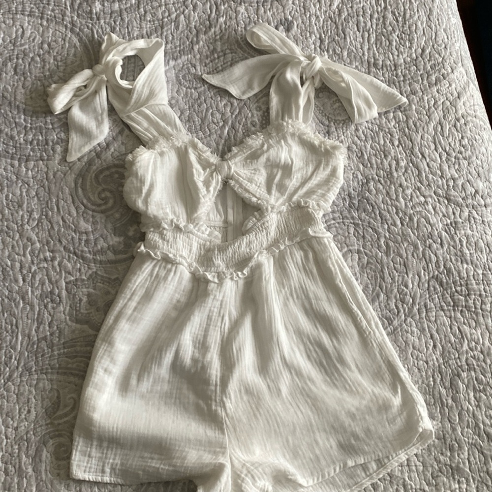 Cute white romper with stomach cut out and tie straps.